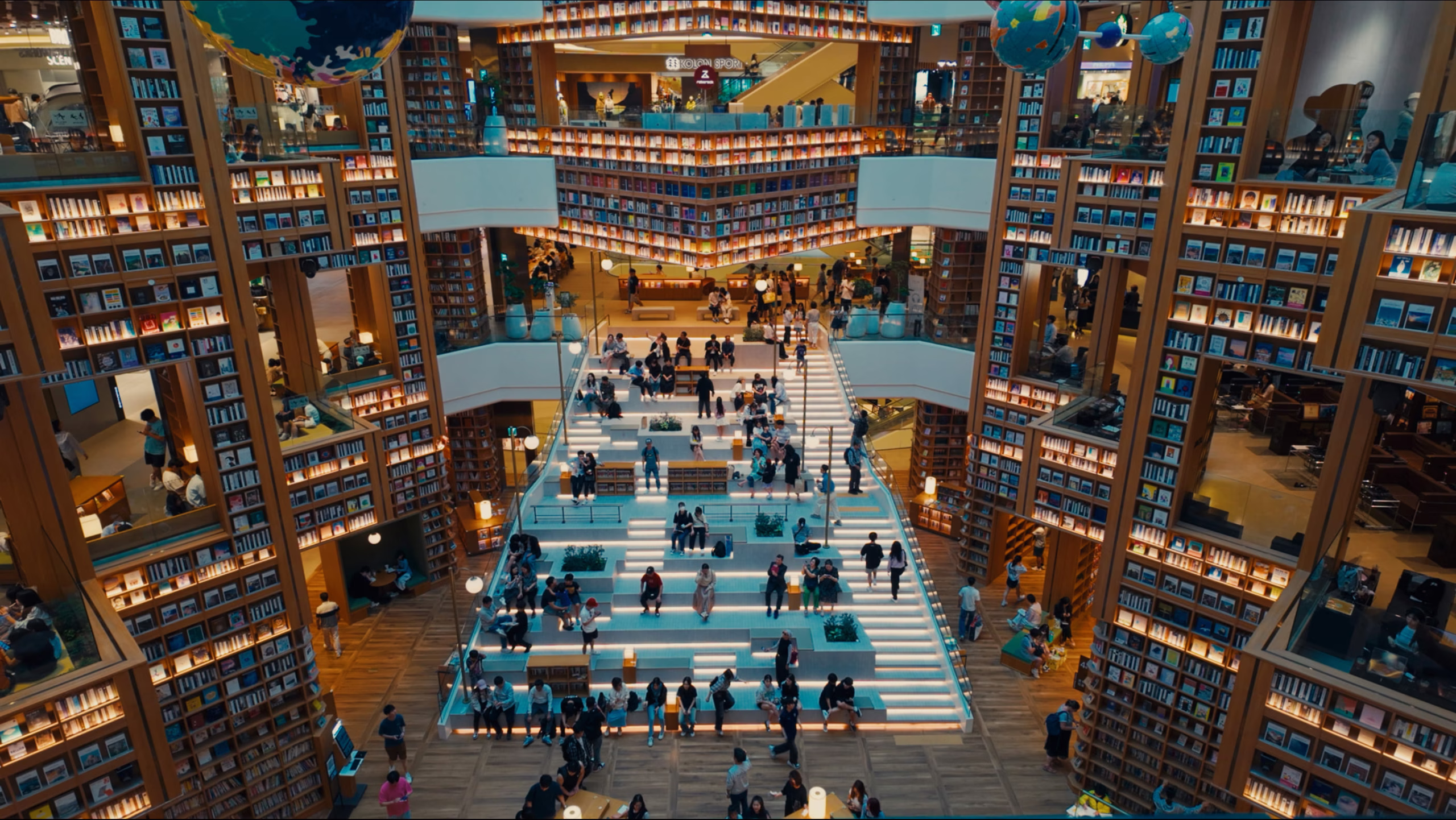 Starfield Suwon Library, people are sitting down on the stairways reading books